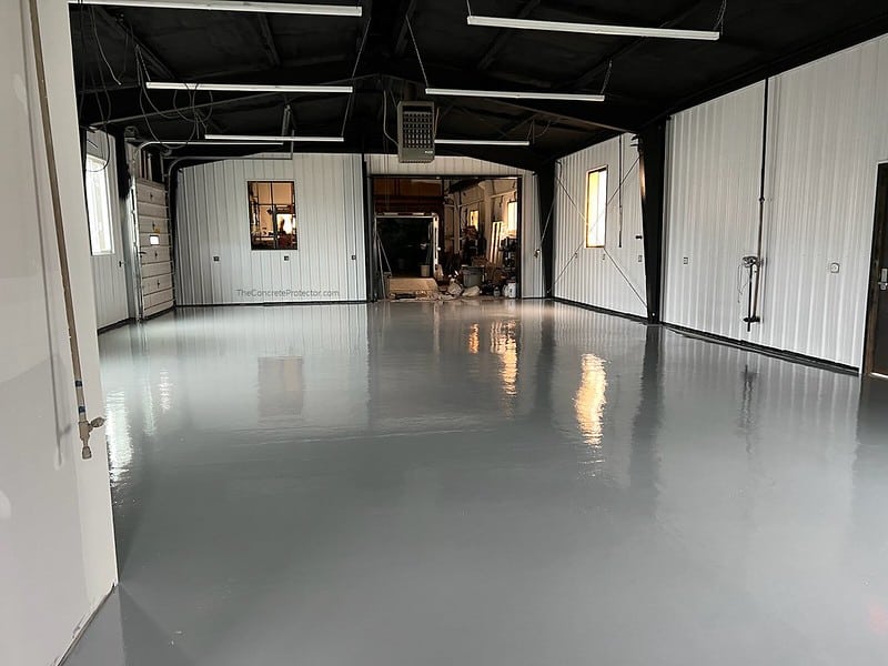 123 Resinous Epoxy Industrial Flooring with a smooth and glossy surface in shades of gray. The flooring is highly durable and ideal for commercial and industrial settings, with a slightly reflective quality that adds depth and texture to the space.